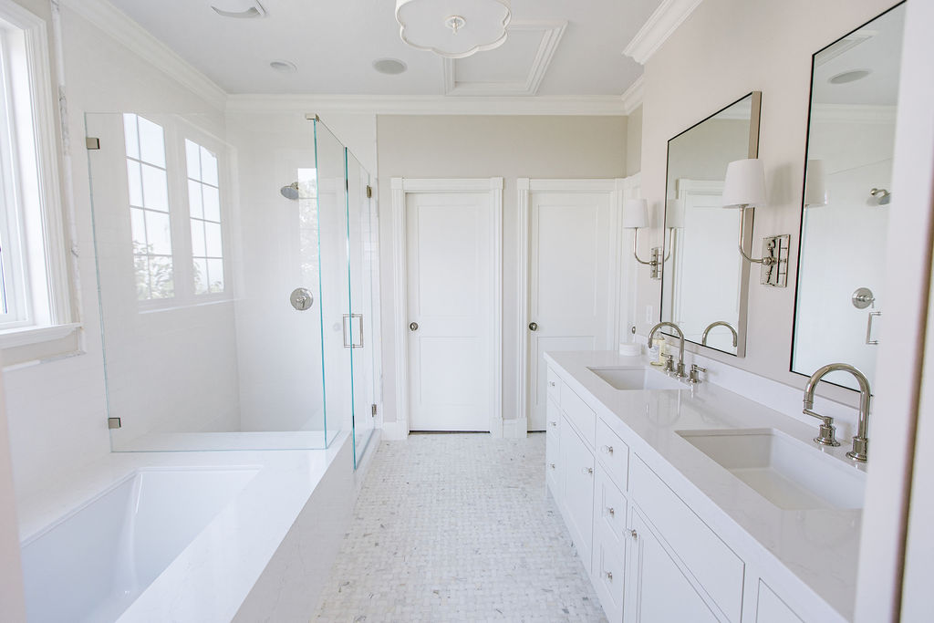 Bright bathroom with white cabinetry and glass shower