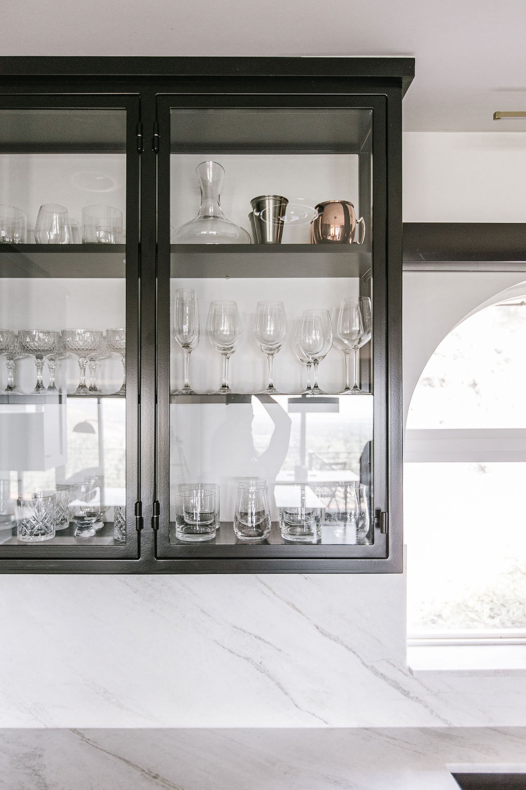 Dark-framed glass display cabinet with marble countertop